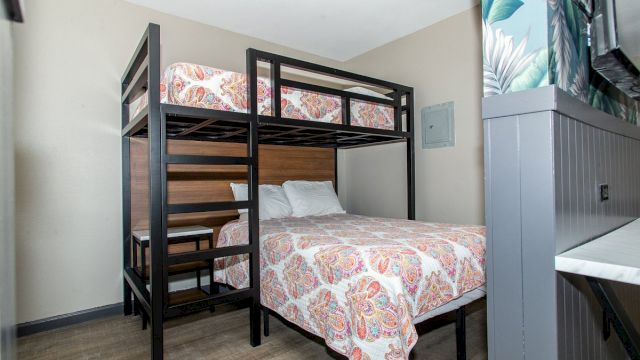 A room with bunk beds and a desk