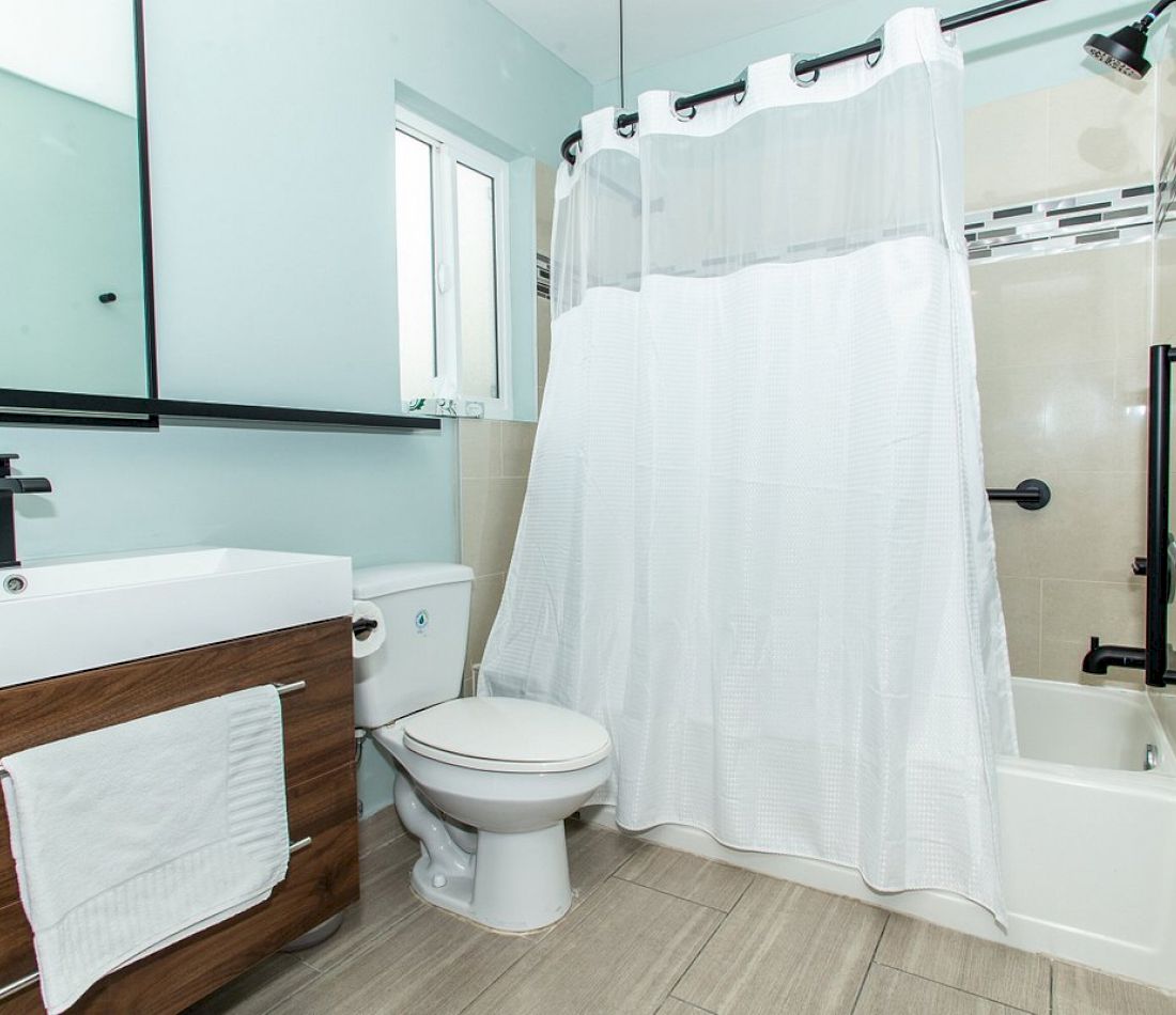 A clean bathroom with a toilet, sink, and shower/bathtub combination