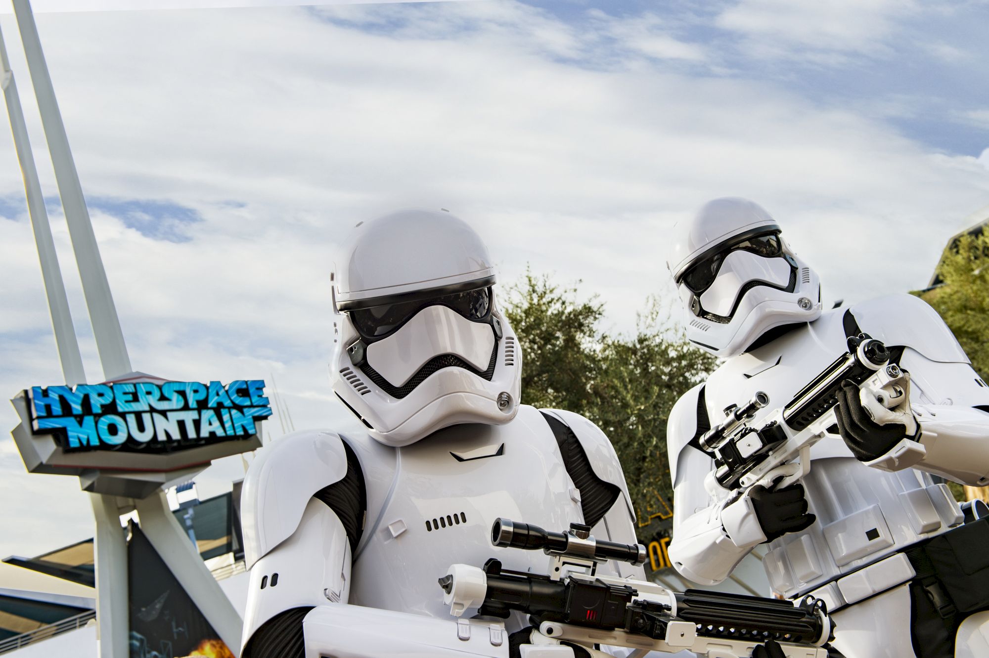 Two Stormtroopers are standing near a sign that reads "Hyperspace Mountain," holding blaster rifles, under a partly cloudy sky.