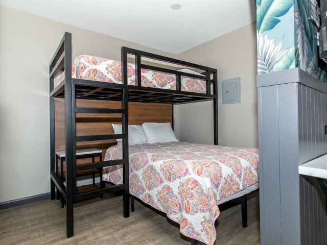A guest room with bunk beds, a dresser, and a TV.