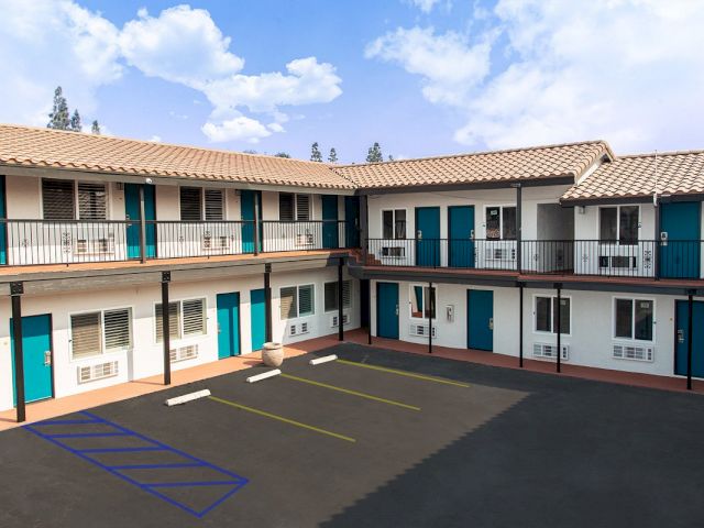 A two-story white building with blue doors and balconies